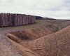 The excavated material was heaped up into an earthen bank, secured with coconut matting, and later grassed over.