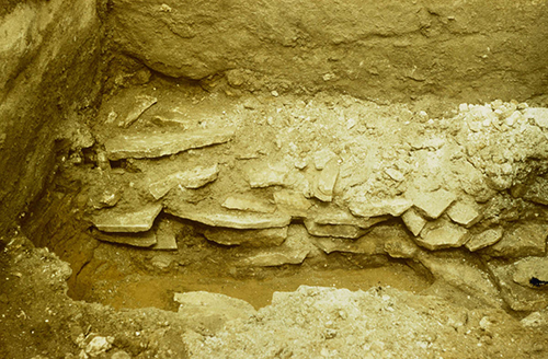 Section N–O: Section through the slab paving, photo taken from the west. To the left: the first side stone of the chamber’s northern wall, in the foreground: the terminal slab. © LDA. 